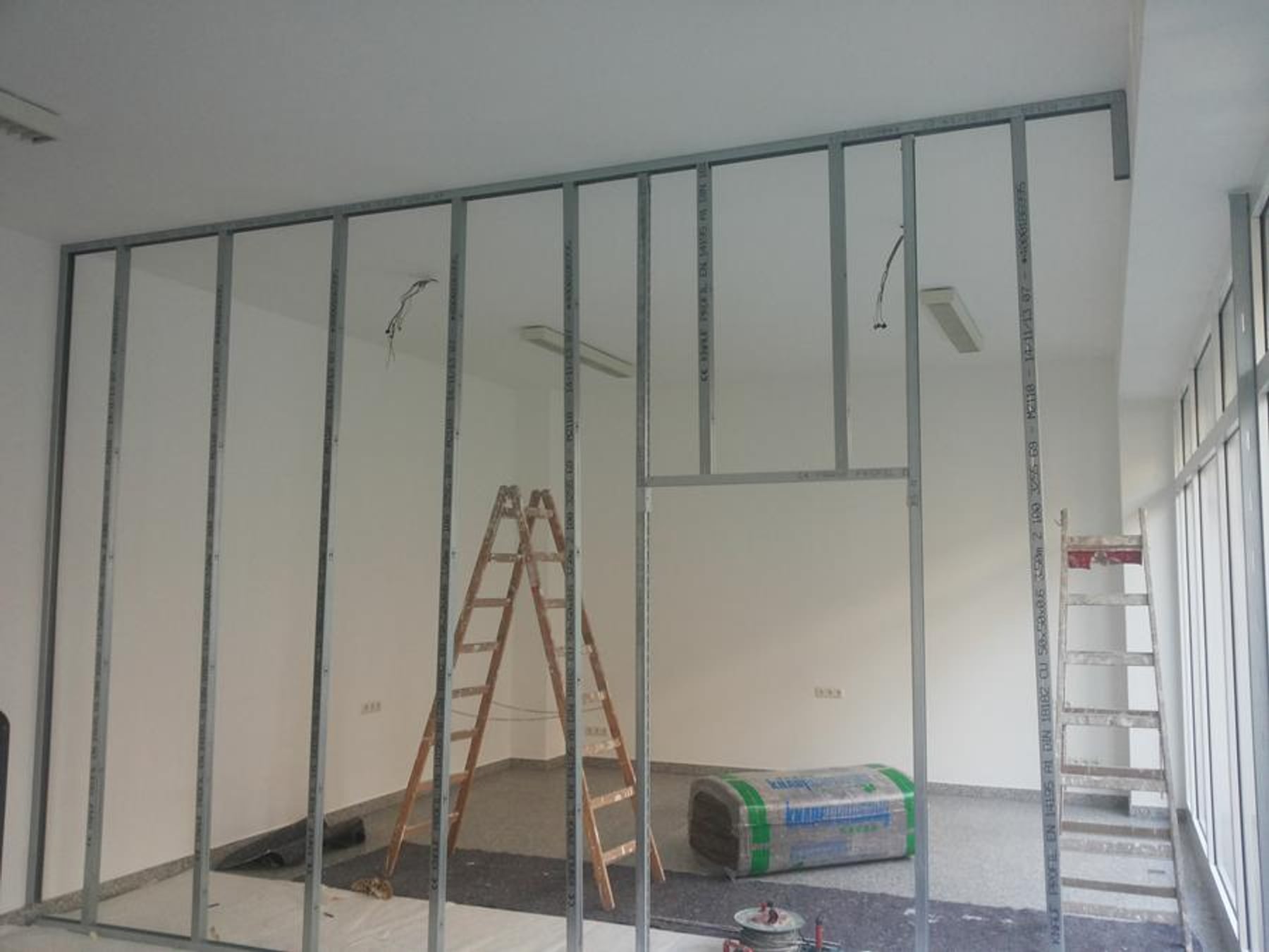 Wohnzimmer mit dunkelgrün gestalteter Wand und Bildergalerie